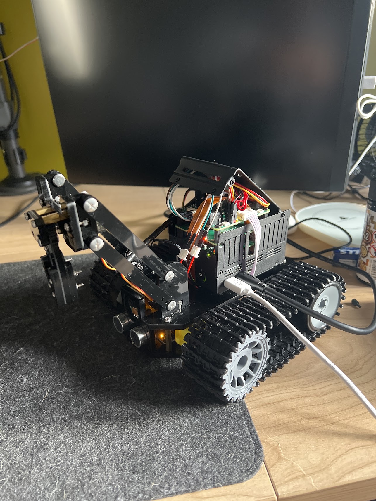 Edge AI Robot side view with tank treads and articulated arm