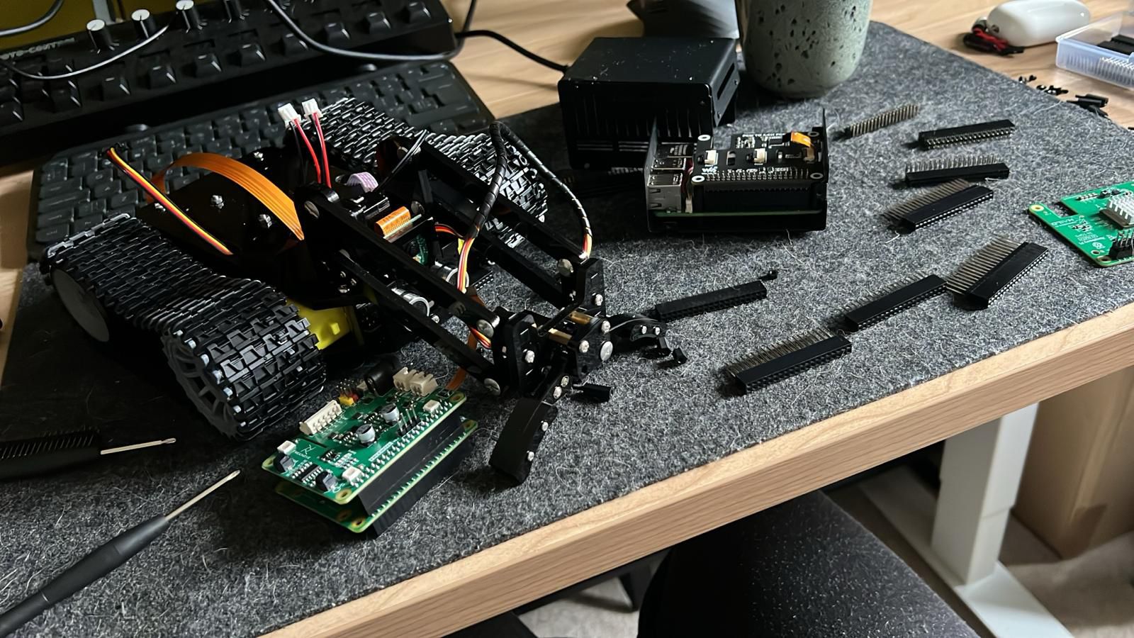 Robot chassis with Raspberry Pi and components on workbench